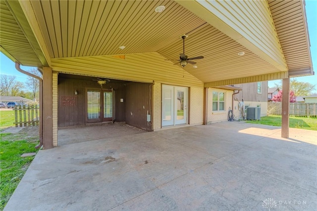 view of patio featuring cooling unit, an attached carport, fence, a ceiling fan, and french doors