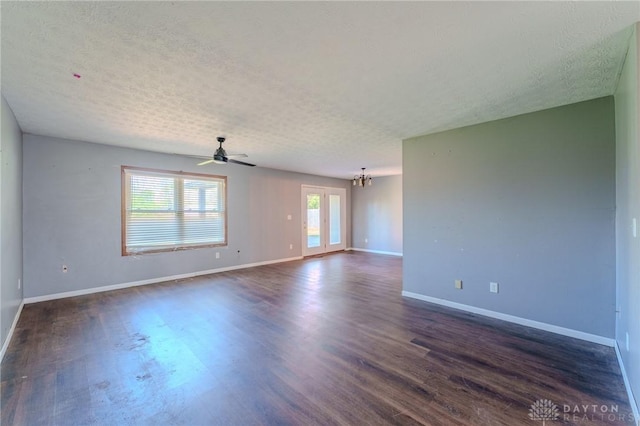 unfurnished room featuring baseboards, ceiling fan with notable chandelier, a textured ceiling, and dark wood-type flooring