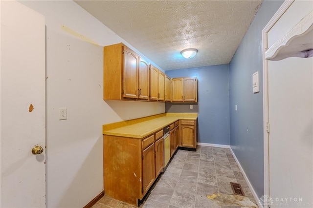 laundry room with a textured ceiling, visible vents, and baseboards