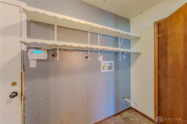 washroom with baseboards and hookup for a washing machine