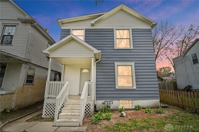 traditional-style home with covered porch and fence