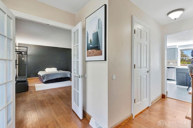 hallway featuring light wood-style floors and french doors