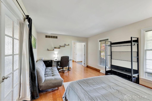 bedroom featuring visible vents, wood finished floors, and baseboards