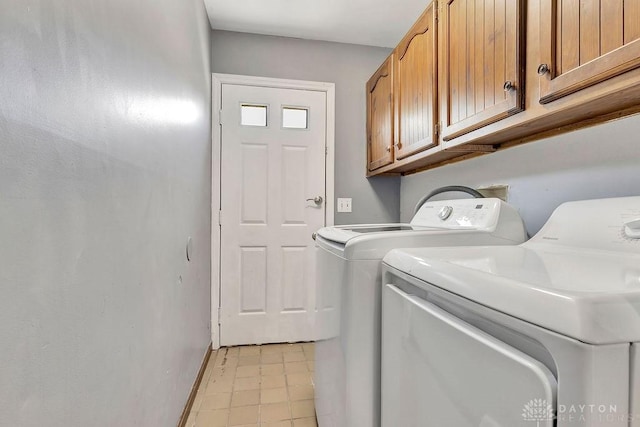 laundry area with light tile patterned floors, cabinet space, baseboards, and washer and clothes dryer