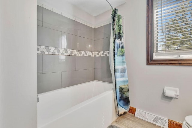 full bath with shower / tub combo, visible vents, and wood finished floors