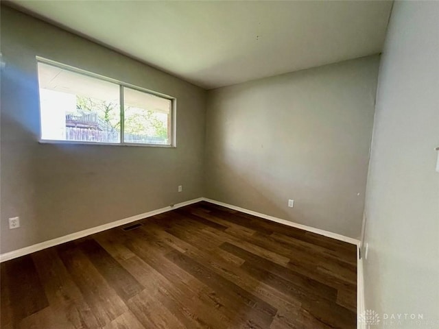 empty room featuring wood finished floors and baseboards