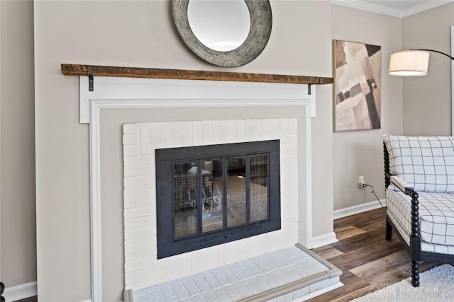 room details featuring baseboards, wood finished floors, ornamental molding, and a fireplace
