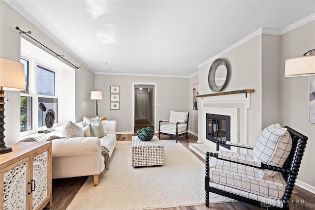 living room with crown molding, wood finished floors, and a glass covered fireplace