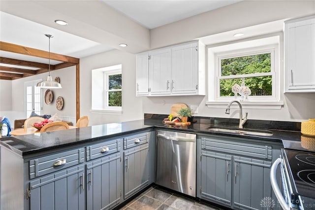 kitchen featuring white cabinetry, a peninsula, appliances with stainless steel finishes, and a sink