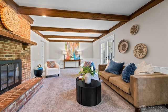 carpeted living room with wainscoting, beamed ceiling, french doors, and a fireplace