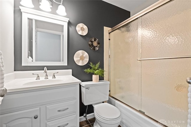 full bathroom featuring bath / shower combo with glass door, toilet, and vanity