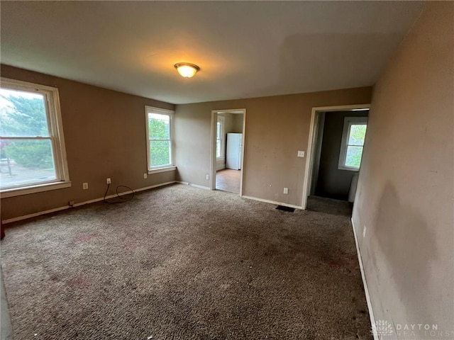 carpeted empty room with baseboards
