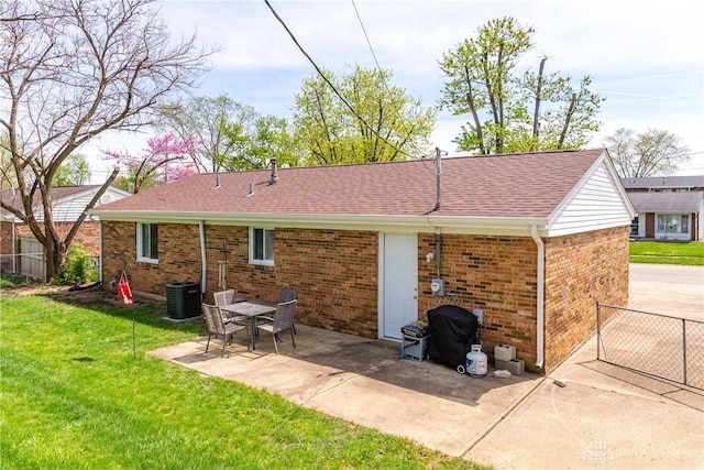 rear view of property with a lawn, fence, a patio area, and brick siding