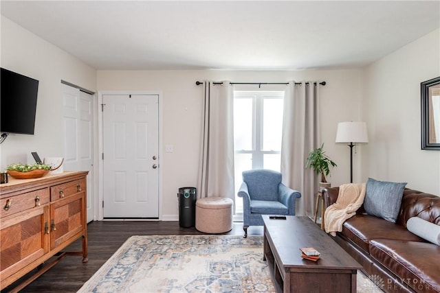 living area featuring dark wood-style flooring and baseboards