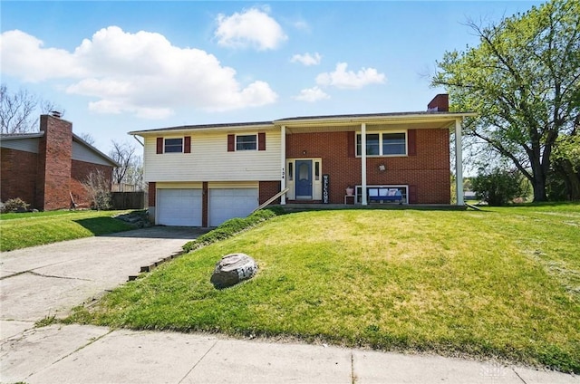 split foyer home featuring brick siding, a front lawn, driveway, and an attached garage