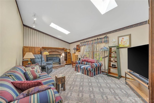 living area with carpet, ornamental molding, a brick fireplace, baseboards, and lofted ceiling with skylight