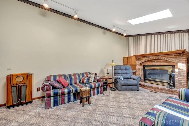 living area featuring a skylight, carpet flooring, rail lighting, and a fireplace
