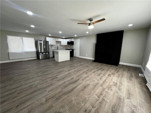 kitchen featuring recessed lighting, white cabinetry, freestanding refrigerator, baseboards, and open floor plan