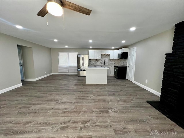 kitchen featuring a center island, open floor plan, white cabinets, appliances with stainless steel finishes, and wood finished floors
