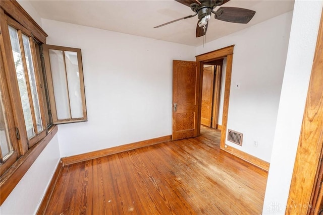 unfurnished room featuring visible vents, ceiling fan, wood finished floors, and baseboards
