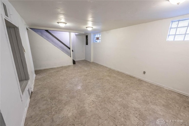 below grade area featuring stairs and baseboards
