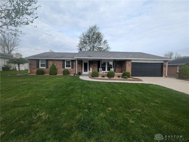 ranch-style house with a garage, brick siding, a front lawn, and driveway