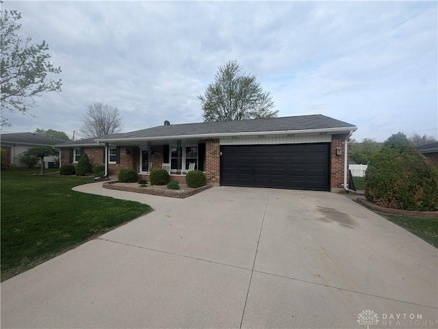 ranch-style house featuring a garage, brick siding, a front yard, and concrete driveway