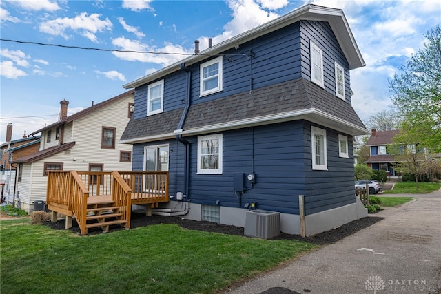9 Wiltshire Blvd, Oakwood, OH 45419 - back of house featuring a lawn, a wooden deck, a shingled roof, and central AC unit