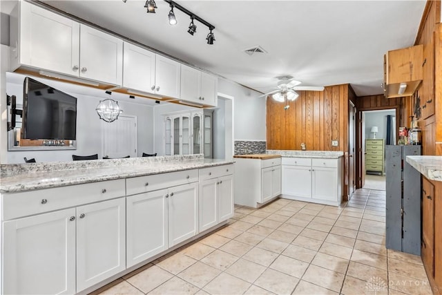 5262 Bittersweet Dr, Washington Twp, OH 45429 - kitchen with wood walls, ceiling fan with notable chandelier, white cabinetry, visible vents, and light tile patterned flooring