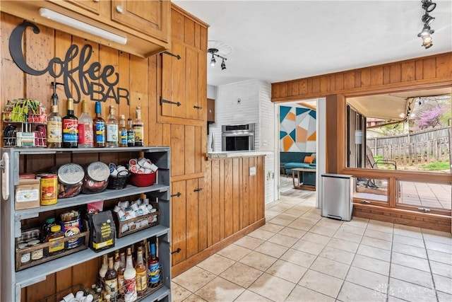 5262 Bittersweet Dr, Washington Twp, OH 45429 - kitchen featuring wood walls, light tile patterned floors, and stainless steel oven