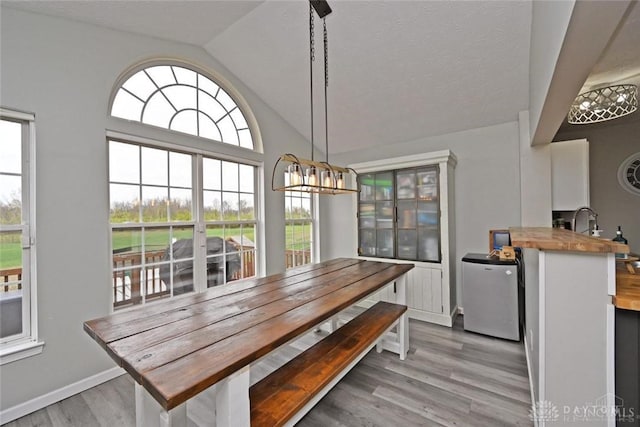 171 Pleasant Hill Blvd, Franklin, OH 45005 - dining area featuring light wood-style floors, baseboards, vaulted ceiling, and an inviting chandelier
