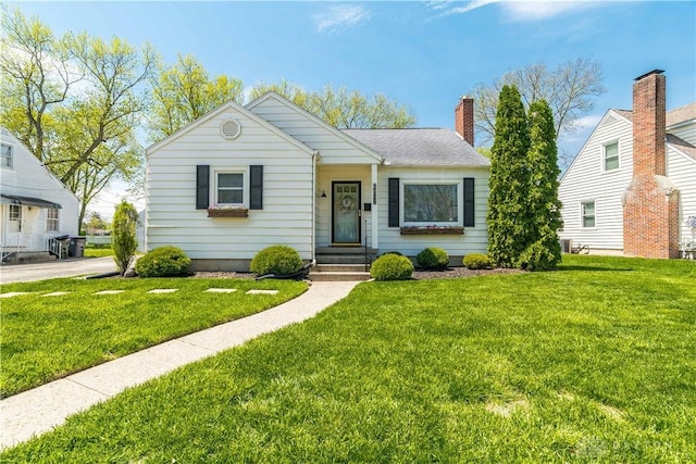 bungalow-style home with a chimney and a front yard