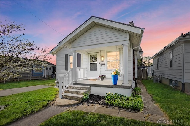 1708 Patterson Rd, Dayton, OH 45420 - shotgun-style home featuring a chimney, a porch, a lawn, and central air condition unit