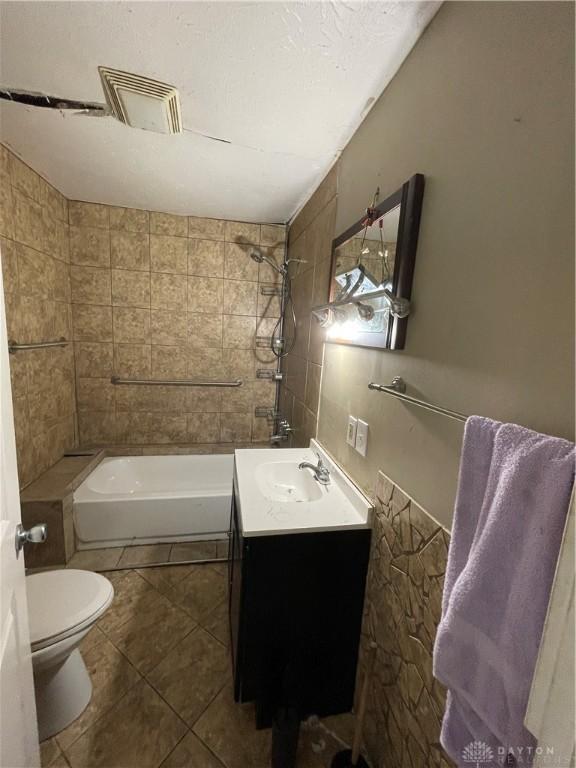 bathroom featuring shower / bathing tub combination, visible vents, toilet, tile patterned floors, and vanity