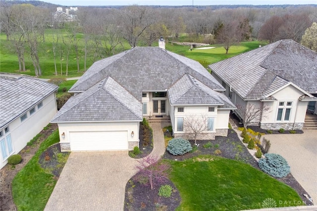 view of front of home with french doors, stucco siding, an attached garage, and stone siding