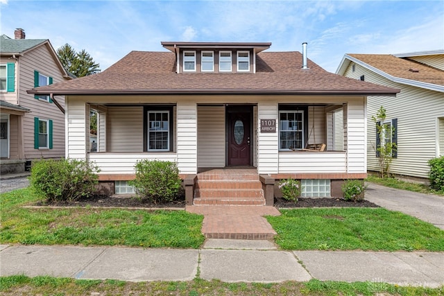 bungalow featuring covered porch and a shingled roof