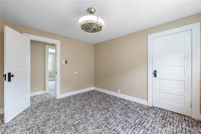 carpeted spare room featuring baseboards