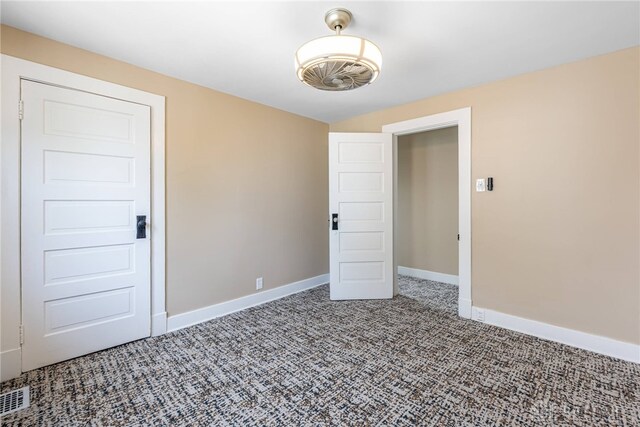 empty room featuring baseboards, visible vents, and carpet