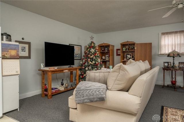 carpeted living area with ceiling fan and baseboards