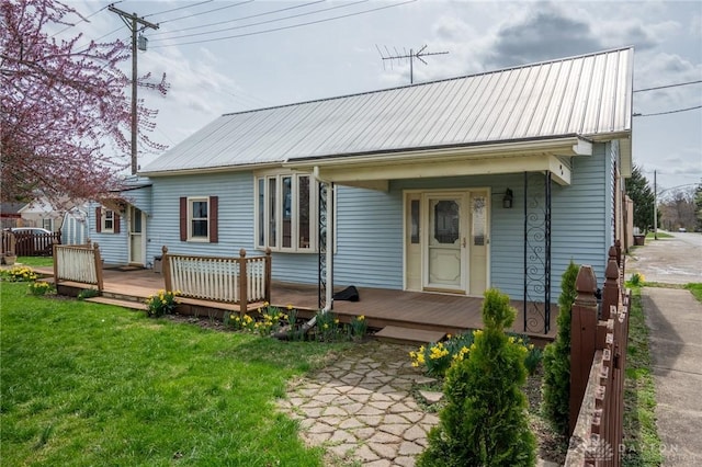 view of front facade with a front yard and metal roof