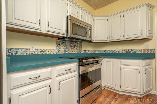kitchen with white cabinetry, stainless steel appliances, and wood finished floors