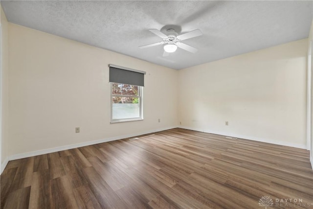 unfurnished room with baseboards, wood finished floors, ceiling fan, and a textured ceiling