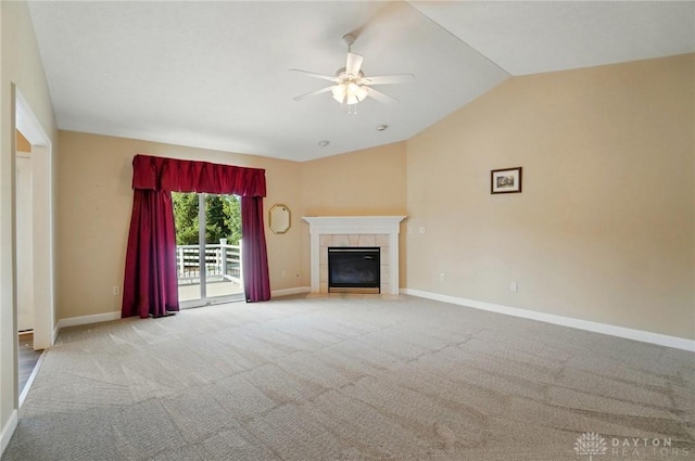 unfurnished living room with a tile fireplace, carpet flooring, baseboards, a ceiling fan, and lofted ceiling