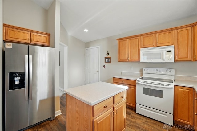 kitchen with dark wood-type flooring, light countertops, a kitchen island, and white appliances