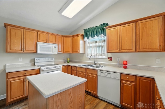 kitchen with lofted ceiling, wood finished floors, white appliances, and a sink