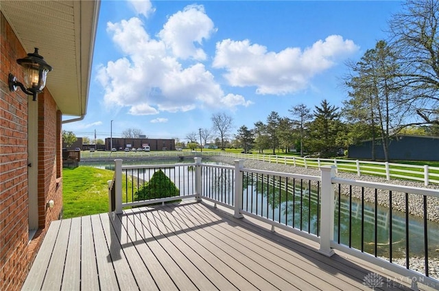 wooden terrace featuring fence and a water view