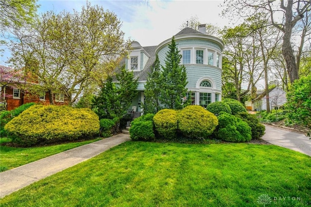victorian home with a front lawn and a chimney