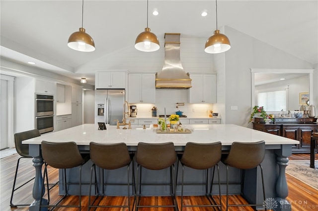 5017 Ackerman Blvd, Kettering, OH 45429 - kitchen featuring appliances with stainless steel finishes, lofted ceiling, custom exhaust hood, a sink, and white cabinetry