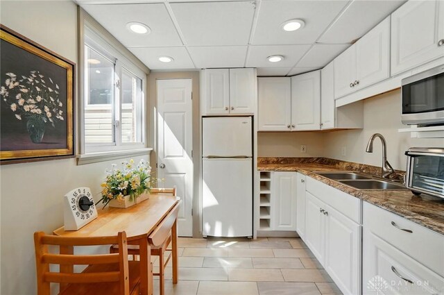 5017 Ackerman Blvd, Kettering, OH 45429 - kitchen featuring freestanding refrigerator, stainless steel microwave, white cabinetry, light tile patterned floors, and recessed lighting
