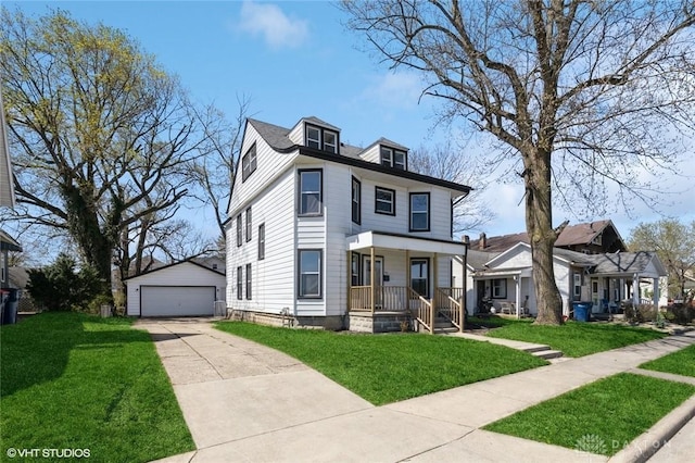 american foursquare style home featuring covered porch, an outdoor structure, a detached garage, and a front yard